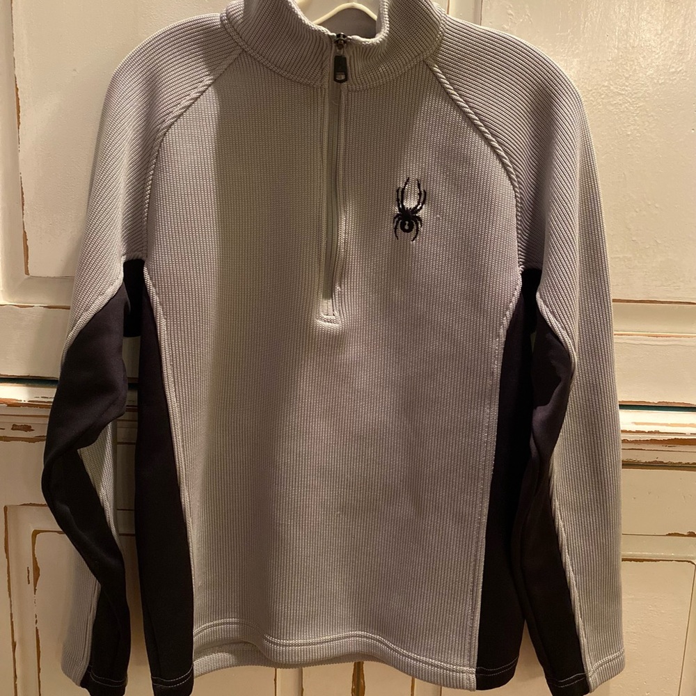 Black and light gray Spyder pullover with half zipper in front .